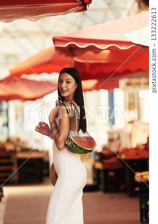 Just bought the watermelon. Young woman is on the vegetable market or bazaar Just bought the watermelon. Young woman is on the vegetable market or bazaar 133222613