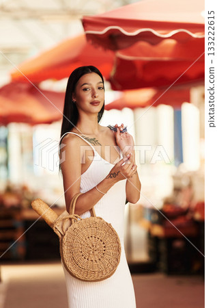 Standing and posing. Young woman is on the vegetable market or bazaar Standing and posing. Young woman is on the vegetable market or bazaar 133222615