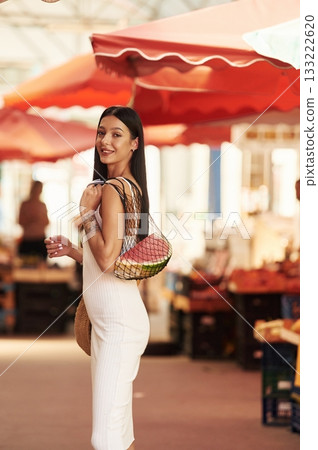 Just bought the watermelon. Young woman is on the vegetable market or bazaar 133222620