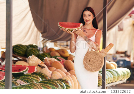Tattooed young woman is on the vegetable market or bazaar Tattooed young woman is on the vegetable market or bazaar 133222632