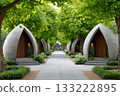 Modern concrete pods line a tranquil tree lined pathway in a peaceful garden setting 133222895
