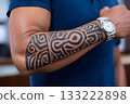 Man showing polynesian tattoo on forearm 133222898