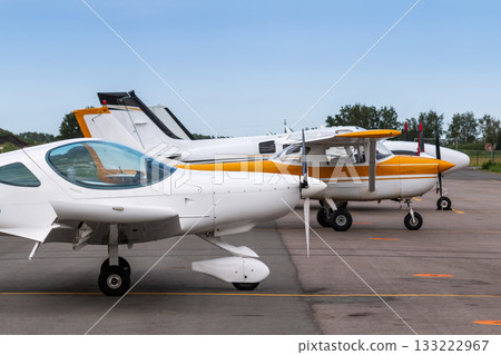Small private airplanes parked at the airfield 133222967