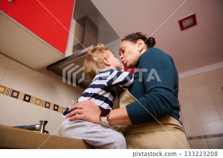 Mother And Child Share Tender Kiss While Cooking Together In Cozy Kitchen 133223208