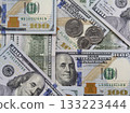 Hundred-dollar bills and some coins as background. 133223444