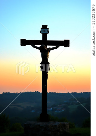 Cross with the name Jesus Christ on it is standing in a field Cross with the name Jesus Christ on it is standing in a field 133223679