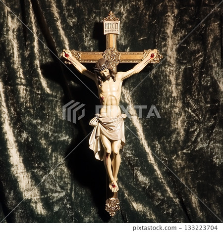 Crucifix is displayed on a green velvet background 133223704