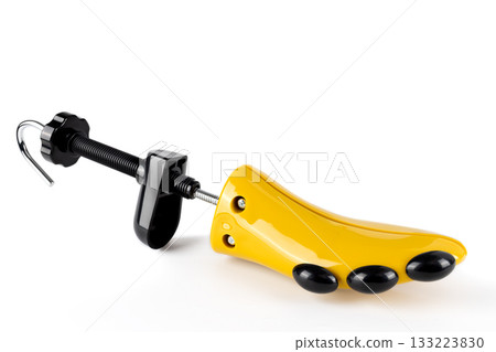 Plastic shoe stretchers with metal screw clamp hook for stretching tight shoes on white background. 133223830