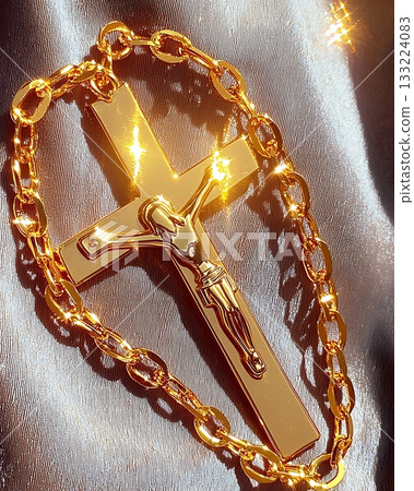 Gold cross with a man on it is hanging from a chain Gold cross with a man on it is hanging from a chain 133224083