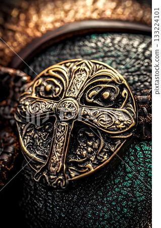 Gold cross is on a leather strap 133224101