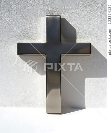 Silver cross is on a white wall 133224125