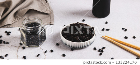 Fermented black douchi beans in a bowl on the table web banner Fermented black douchi beans in a bowl on the table web banner 133224170