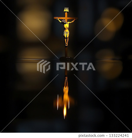 Golden cross with a man on top of it is reflected in the water 133224241