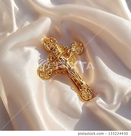 Gold cross with a crucifix on it sits on a white background 133224430