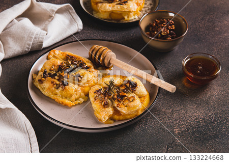 Pumpkin, cheese, nuts and rosemary baked with honey topping on a plate on the table 133224668