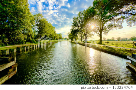 Enjoy the Beauty of a Serene River Landscape Surrounded by Lush Greenery and Its Reflection 133224764