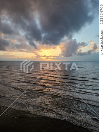 A beautiful Serene Sunset Over Calm Ocean Waves creates an atmosphere of tranquility and peace A beautiful Serene Sunset Over Calm Ocean Waves creates an atmosphere of tranquility and peace 133224766