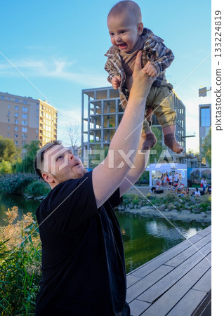 Father Lifting Smiling Baby Outdoors Father Lifting Smiling Baby Outdoors 133224819