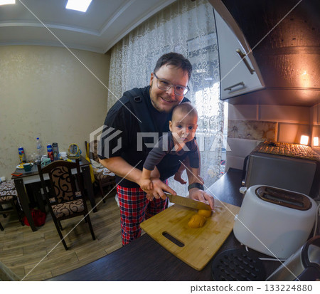Father Cooking with Baby in Carrier 133224880