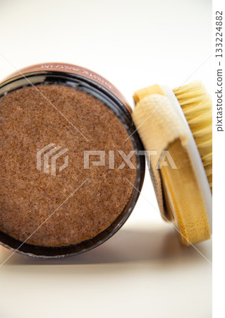 Round container of brown sugar body scrub with a natural bristle brush, emphasizing beauty and skincare essentials for effective self-care and relaxation Round container of brown sugar body scrub with a natural bristle brush, emphasizing beauty and skincare essentials for effective self-care and relaxation 133224882