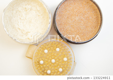 Three jars filled with body scrubs, featuring creamy and granular textures, placed on a clean surface, highlighting the importance of skincare and self-care routines 133224911
