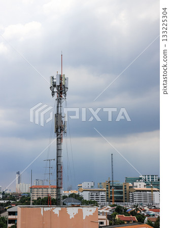 Wireless Communication Antenna pole, Mobile phone mast antenna pole on top of dilapidated building. 133225304