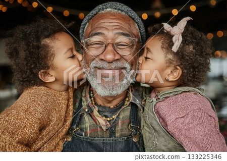 Elderly man with gray beard embraced by two children with joyful expressions 133225346