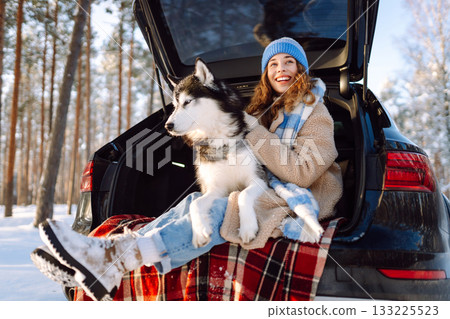 Woman with husky dog have picnic in car trunk near pine forest, traveling by car. Travel concept. 133225523