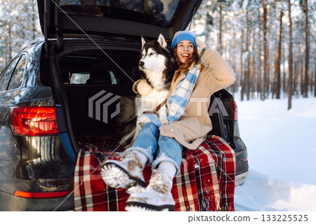 Woman with husky dog have picnic in car trunk near pine forest, traveling by car. Travel concept. 133225525