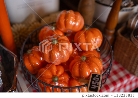 Basket filled with bright miniature pumpkins in a cozy autumn setup. Warm seasonal tones and rustic textures create a festive harvest-inspired scene Basket filled with bright miniature pumpkins in a cozy autumn setup. Warm seasonal tones and rustic textures create a festive harvest-inspired scene 133225935