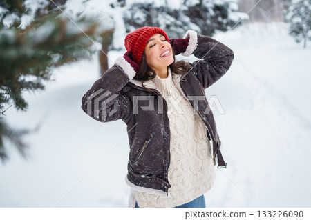 Beautiful Woman Wearing Fashionable Winter Clothes walking in winter nature. Holidays concept. 133226090