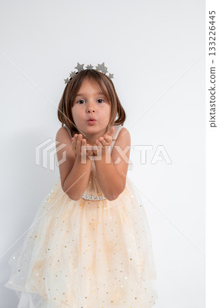 Cute caucasian child blowing kiss wearing star crown and sparkly dress Cute caucasian child blowing kiss wearing star crown and sparkly dress 133226445
