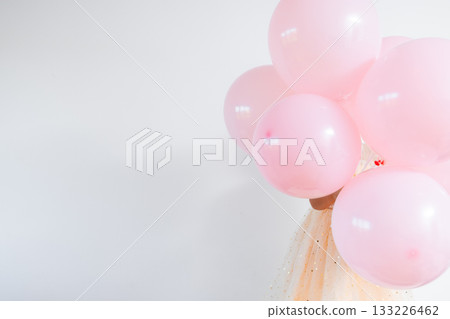 Pink balloons and sparkling tulle dress against white background Pink balloons and sparkling tulle dress against white background 133226462