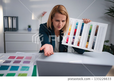 Woman choosing colors on video call, feeling stressed Woman choosing colors on video call, feeling stressed 133226633