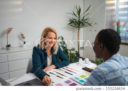 Interior designer woman consulting male client on color palette Interior designer woman consulting male client on color palette 133226634