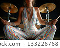 Female musician in sparkling outfit sitting in front of drum set 133226768
