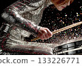 Female drummer performing energetically in sparkling silver outfit with drums 133226771