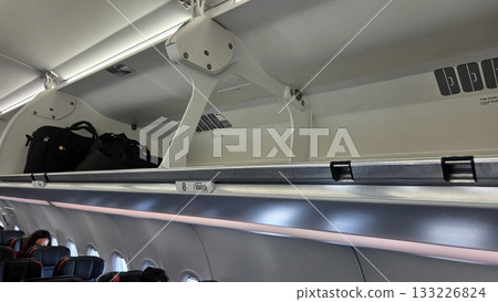 Airplane interior overhead compartment with luggage in modern aircraft cabin Airplane interior overhead compartment with luggage in modern aircraft cabin 133226824