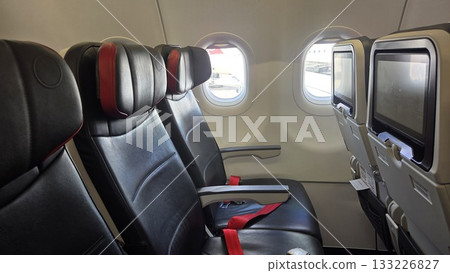 Comfortable airplane interior with empty seats and window view for travel and flight Comfortable airplane interior with empty seats and window view for travel and flight 133226827