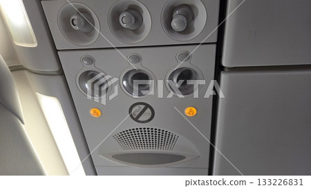 Airplane interior panel with no smoking sign and passenger controls 133226831