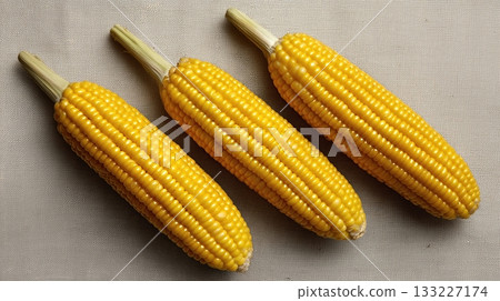 Fresh Corn on Neutral Cloth Surface Showcasing Its Bright Yellow Color and Natural Texture 133227174