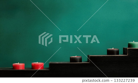 Geometric Arrangement of Red, Black, and Green Candles on a Wooden Step Against a Teal Background Geometric Arrangement of Red, Black, and Green Candles on a Wooden Step Against a Teal Background 133227239