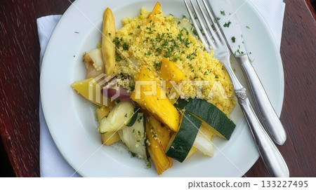 Overhead View of a Vibrant Couscous Dish With Colorful Vegetables Served on a White Plate 133227495