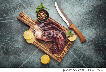 Raw squid octopus wooden cutting board knife gourmet seafood lemon pepper preparing 133227532