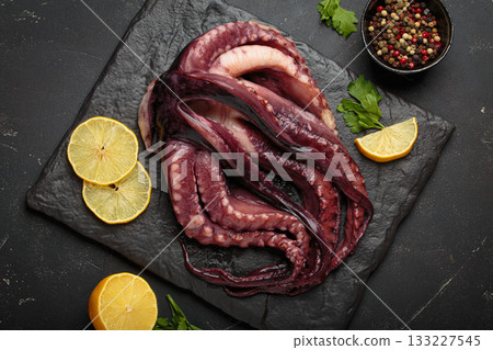 Raw squid octopus black slate gourmet seafood cooking lemon pepper preparing Raw squid octopus black slate gourmet seafood cooking lemon pepper preparing 133227545