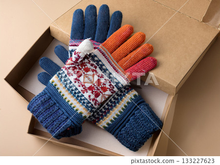 一副手工編織的、色彩鮮豔的北歐風格手套，裝在紙盒裡，是完美的冬季禮物。 133227623