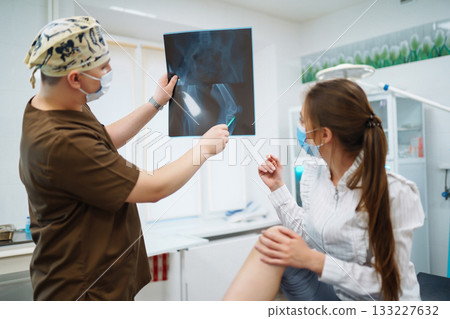 Doctor examines x-ray of patient leg. Foot and sprain concept. Sport exercise injuries. Doctor examines x-ray of patient leg. Foot and sprain concept. Sport exercise injuries. 133227632