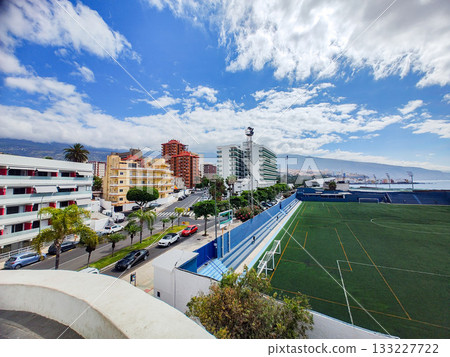 An attractive urban landscape showcasing a vibrant sports field alongside prominent buildings An attractive urban landscape showcasing a vibrant sports field alongside prominent buildings 133227722