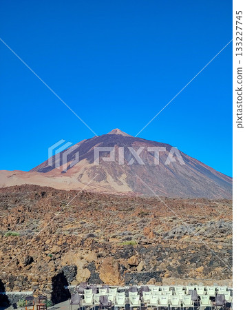 A Majestic Mountain Peak Stands Proudly Against a Clear Blue Sky, Showcasing Natures Beauty A Majestic Mountain Peak Stands Proudly Against a Clear Blue Sky, Showcasing Natures Beauty 133227745