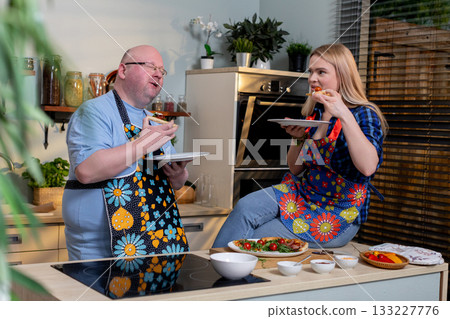 Relaxed evening kitchen interaction, Intimate night with couple at home kitchen, Relaxed couple sharing meal and conversation in cozy kitchen during evening hours 133227776